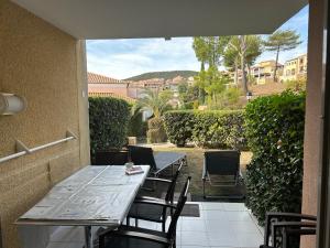 einen Tisch und Stühle auf einer Terrasse in der Unterkunft Appartement 2 pièces climatisé en rez-de-jardin Cap Esterel Agay in Agay - Saint Raphael