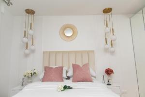 Schlafzimmer mit einem Bett mit rosa Kissen und einem Spiegel in der Unterkunft Paris' Premium Romantic Studio in Paris