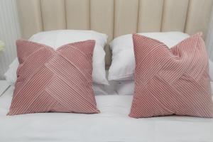 zwei rote und weiße Kissen auf dem Bett in der Unterkunft Paris' Premium Romantic Studio in Paris