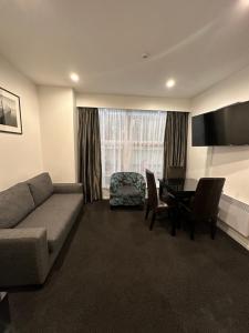 uma sala de estar com um sofá e uma mesa em Gilmer Apartment Hotel em Wellington