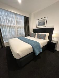a bedroom with a large bed and a window at Gilmer Apartment Hotel in Wellington