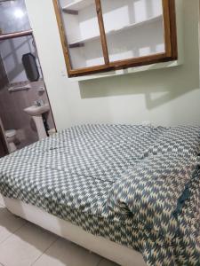 uma cama num quarto com um espelho por cima em WAYNA & WAYLLUY em Talara