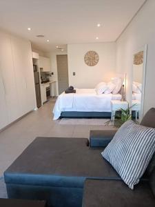 1 dormitorio grande con 1 cama y 1 sofá en Modern comfy studio apartment with pools, en Umhlanga
