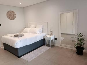 a bedroom with a large bed and a glass shower at Modern comfy studio apartment with pools in Umhlanga