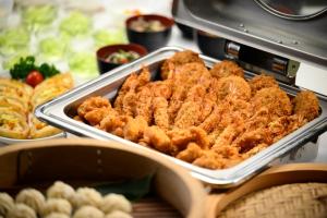 a buffet of food with chicken in a pan at Hotel Tagawa in Yamanouchi