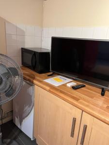 einen großen Flachbild-TV auf einer Theke in der Unterkunft Oxborne Rooms UK - Seaton in London