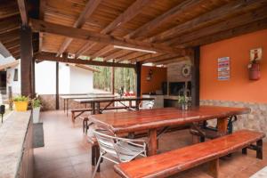 una sala da pranzo con tavoli e panche in legno di Los Alamos a Villa General Belgrano