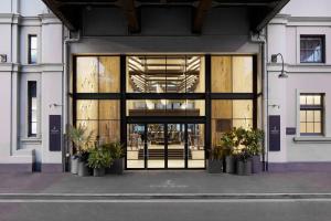 a large glass door to a building with potted plants at Pier One Sydney Harbour, Autograph Collection in Sydney