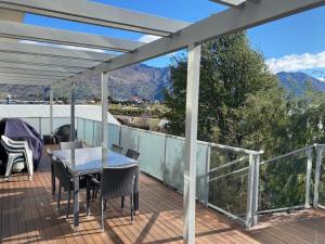 a patio with a table and chairs on a deck at Stunning Bob Lee Place in Wanaka