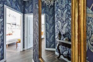 een spiegel in een kamer met blauw behang bij Luxe Garden Apt for 2nr Bologna in Casalecchio di Reno