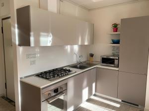 a white kitchen with a stove and a sink at Casa Giulia in Santarcangelo di Romagna
