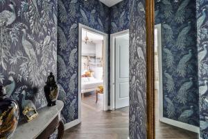 un pasillo con papel pintado azul y espejo en Luxe Garden Apt for 2nr Bologna en Casalecchio di Reno