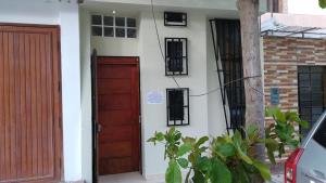uma porta da frente de uma casa com uma porta vermelha em WAYNA & WAYLLUY em Talara