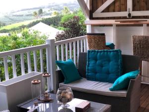 a porch with a chair and a table with a view at Mango in Le Carbet