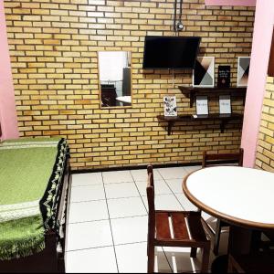 um quarto com uma mesa e uma televisão numa parede de tijolos em La Serena em Florianópolis