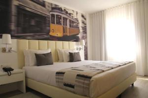 Un dormitorio con una cama grande y una foto de un tren en THE Hotel MASA Almirante LISBON Stylish, en Lisboa