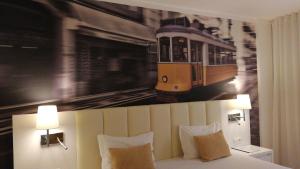 un dormitorio con una pintura de un tren en la pared en THE Hotel MASA Almirante LISBON Stylish, en Lisboa