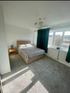 um quarto com uma cama e uma cortina azul em Sittingbourne, Kent em Kent