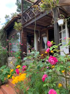 a garden with flowers in front of a house at Romantic house on a pine hill Dalat in Xuan An