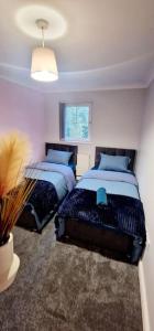 a bedroom with two beds and a window at 9 Guest 7 Beds Lovely House in Rossendale in Newchurch