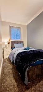 a bedroom with a large bed and a window at 9 Guest 7 Beds Lovely House in Rossendale in Newchurch