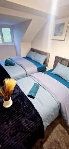 a bedroom with two beds with blue and white at 9 Guest 7 Beds Lovely House in Rossendale in Newchurch