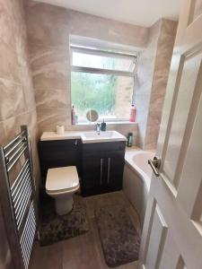 uma casa de banho com um lavatório, um WC e uma janela. em Sittingbourne, Kent em Kent