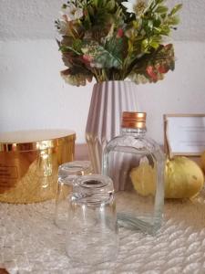 a glass jar and a vase with flowers in it at Studio Apartman Ivan in Otočac