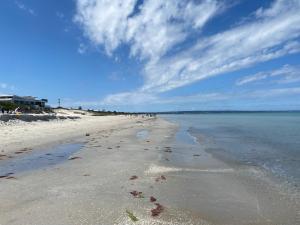 a beach with a few footprints in the sand at 5 Beds-Whole House-Carrum Beach- Patterson Lake-Fully Furnished in Carrum