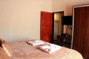 a bedroom with a bed with two towels on it at La Quinta Resort in Merlo