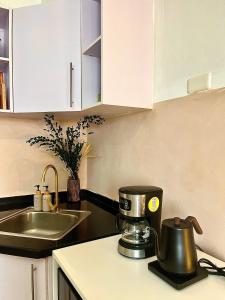 a kitchen with a mixer on a counter next to a sink at Avida Studio unit in Davao City