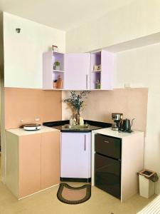 a small kitchen with white cabinets and a sink at Avida Studio unit in Davao City