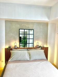 a bedroom with a large white bed with a window at Avida Studio unit in Davao City