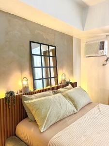 a bedroom with a bed with a mirror above it at Avida Studio unit in Davao City