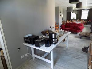 a living room with a white table with a microwave at Die Alte Bäckerei in Jöhstadt