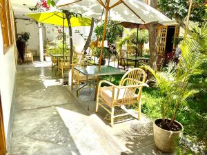 un patio con mesas, sillas y sombrillas en Garden House Ica en Ica