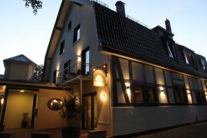 a white building with a black roof at Nella Parkhotel in Steinhude