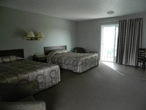 a hotel room with two beds and a large window at Hilltop Motel & Restaurant in Grand Falls