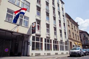 un edificio con una bandera a un lado. en HI Hostel Zagreb, en Zagreb