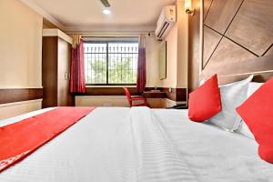 a bedroom with a large bed with red pillows at OYO Hotel Star Ldh in Ludhiana
