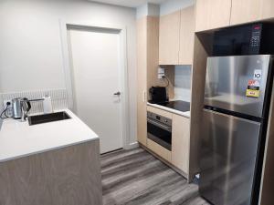 a kitchen with a stainless steel refrigerator and a sink at Home@Braddon in Canberra