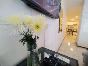 un jarrón lleno de flores blancas sentado en una mesa en MENDOZA SUITES en Mendoza