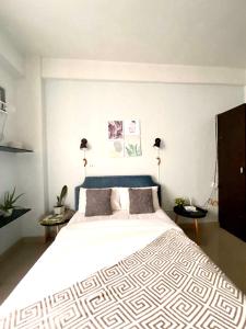 a bedroom with a large white bed with two lamps at Eco Friendly Studio Rooms Edsa Mandaluyong Shaw at F Residences under New Management in Manila