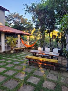 un patio con mesa, sillas y hamaca en Vila Mulungu Casa, en Mulungu