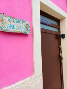 un edificio rosa con un cartello accanto a una porta di Casa Candelita a Valladolid