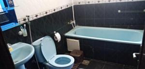 La salle de bains est pourvue de toilettes, d'un lavabo et d'une baignoire. dans l'établissement Repos Surf House 1, à Sidi Ifni