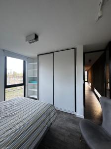 a bedroom with a bed and a chair in it at Casa del cerro 1 - Three Houses in La Rioja