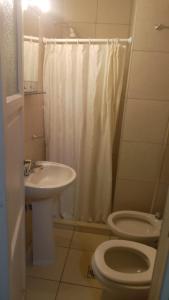 a bathroom with a sink and a toilet and a shower at Hotel Cristal in Mendoza