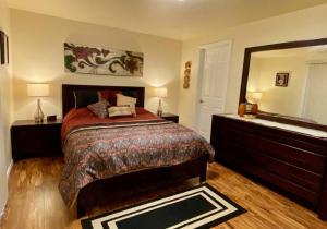 a bedroom with a bed and a dresser and a mirror at Hidden Gem in SE Boise with hot tub and wood burning fireplace in Boise