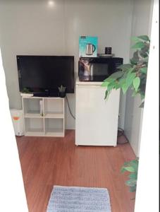 a living room with a flat screen tv and a table at The City Dweller Kingaroy in Kingaroy